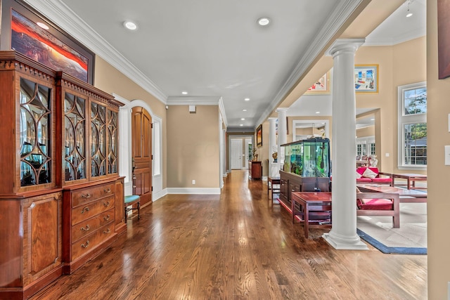 foyer entrance with wood-type flooring, crown molding, and decorative columns