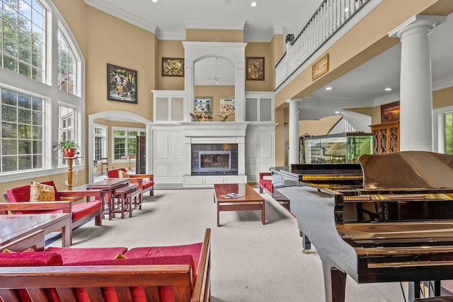 carpeted living room featuring a healthy amount of sunlight, a fireplace, and a high ceiling