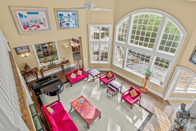 living room with a high ceiling and ceiling fan