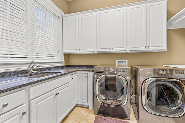 laundry room featuring washer and clothes dryer, light tile patterned flooring, cabinets, and sink