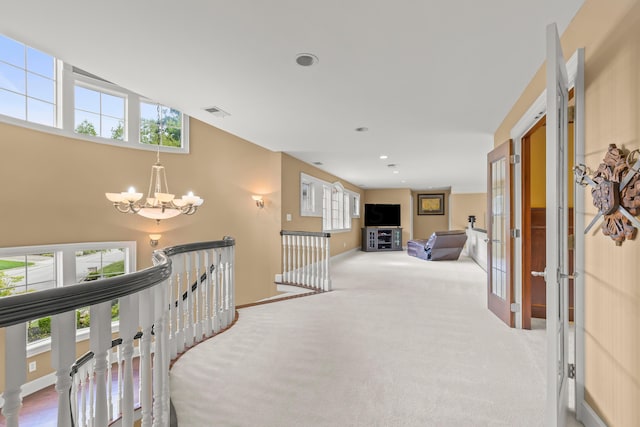 corridor featuring carpet floors and an inviting chandelier