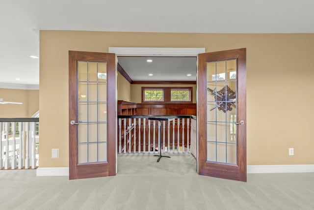 interior space with light carpet, french doors, and crown molding