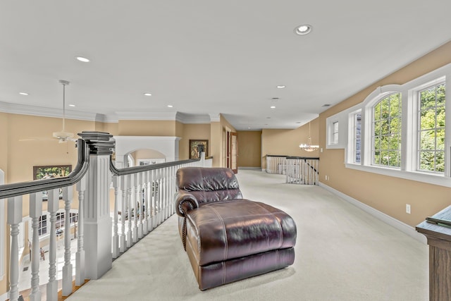 sitting room featuring ceiling fan with notable chandelier, light colored carpet, and ornamental molding