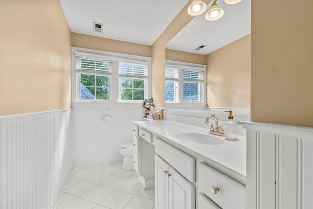 bathroom featuring tile patterned floors, vanity, a healthy amount of sunlight, and toilet