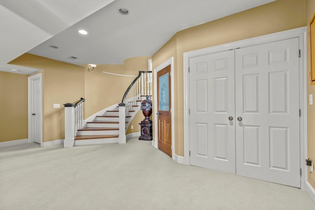 foyer entrance featuring light colored carpet