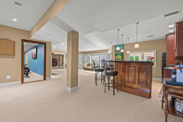 bar with black fridge, light carpet, and pendant lighting