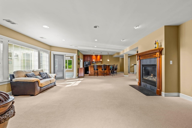 living room featuring a fireplace, light carpet, and indoor bar