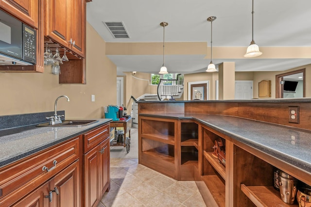 kitchen with sink, light tile patterned flooring, and pendant lighting