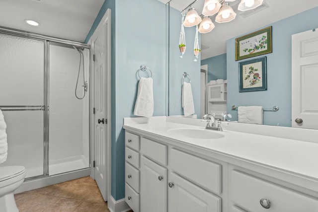 bathroom with tile patterned floors, a shower with door, vanity, and toilet