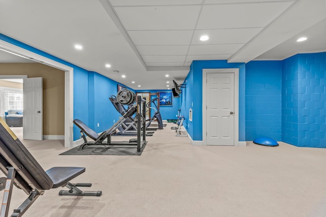 workout area with a drop ceiling and light colored carpet