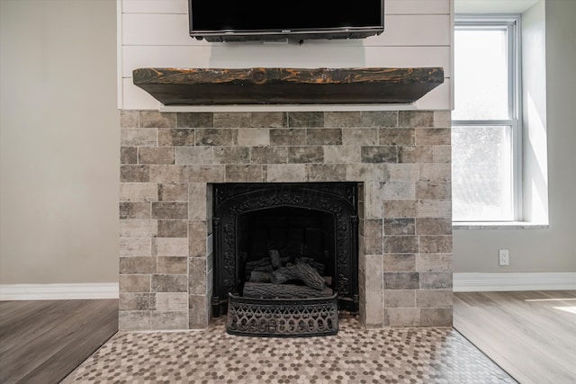 room details with hardwood / wood-style floors and a tile fireplace