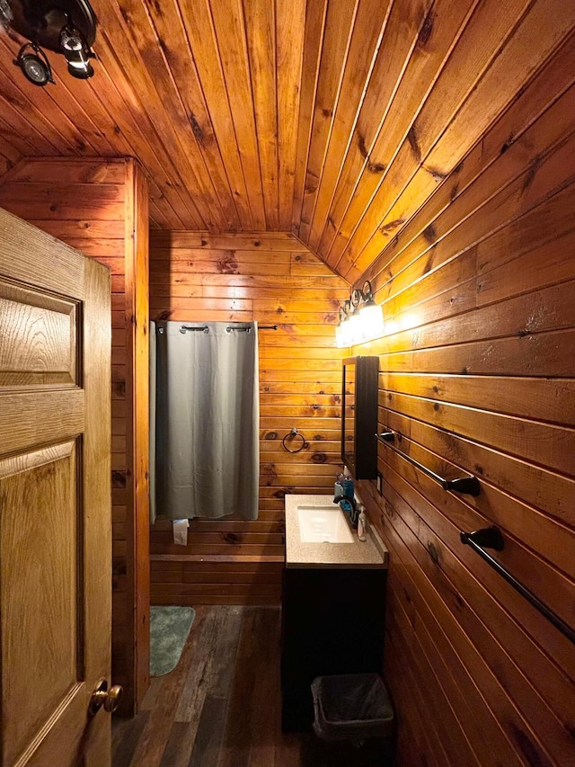 bathroom with vanity, lofted ceiling, wood-type flooring, wooden walls, and wood ceiling