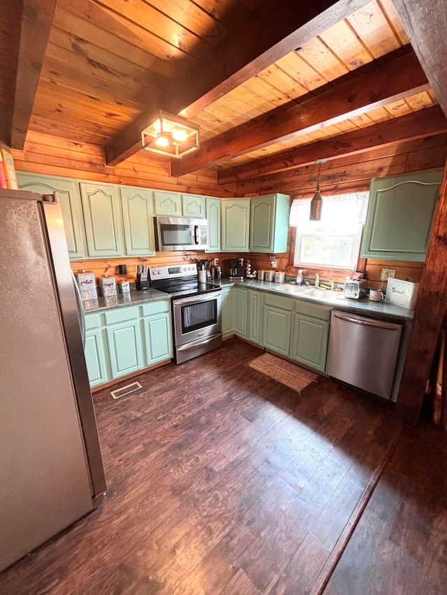 kitchen with beamed ceiling, stainless steel appliances, dark hardwood / wood-style floors, and green cabinets