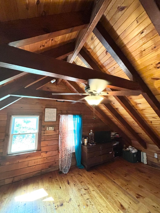 additional living space featuring vaulted ceiling with beams, light hardwood / wood-style floors, wooden ceiling, and wood walls