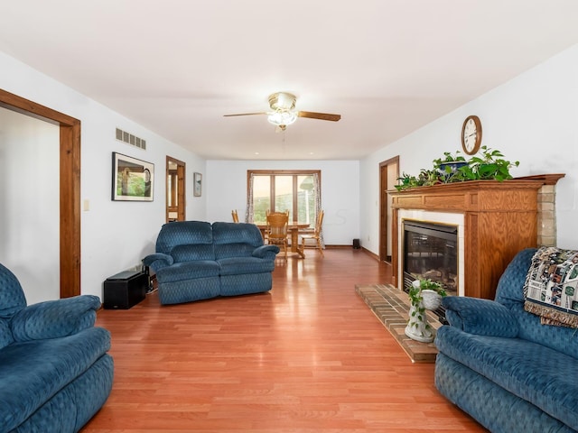 living room with ceiling fan and light hardwood / wood-style flooring