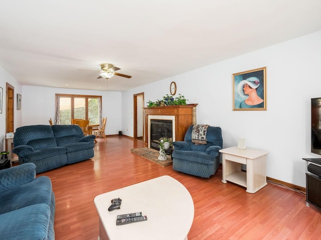 living room with a fireplace, ceiling fan, and hardwood / wood-style floors