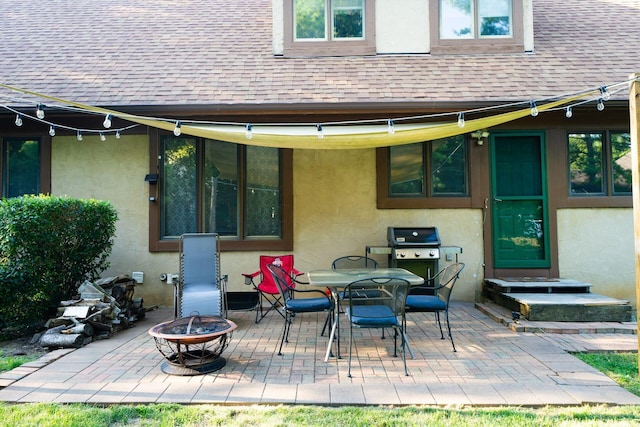 rear view of house with a patio area and an outdoor fire pit