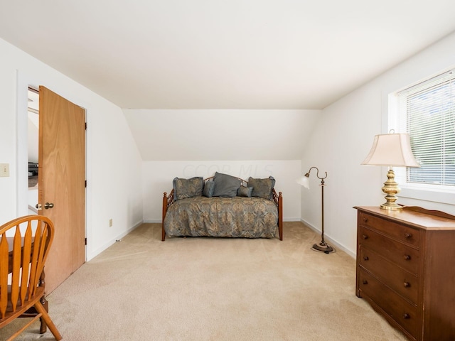 bedroom with light carpet and lofted ceiling