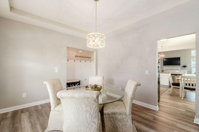 dining room featuring light hardwood / wood-style floors and a notable chandelier