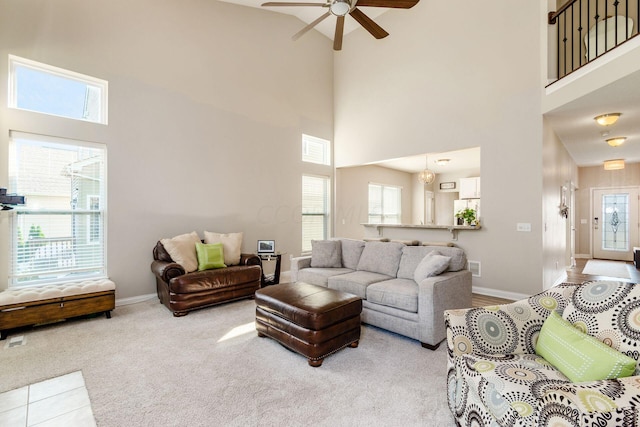 living room featuring carpet, ceiling fan, and a high ceiling