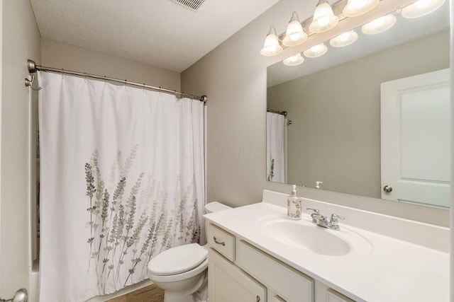 bathroom with vanity, a textured ceiling, and toilet