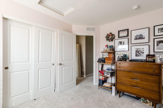 bedroom featuring light carpet, a closet, and a textured ceiling