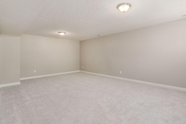 spare room featuring carpet and a textured ceiling