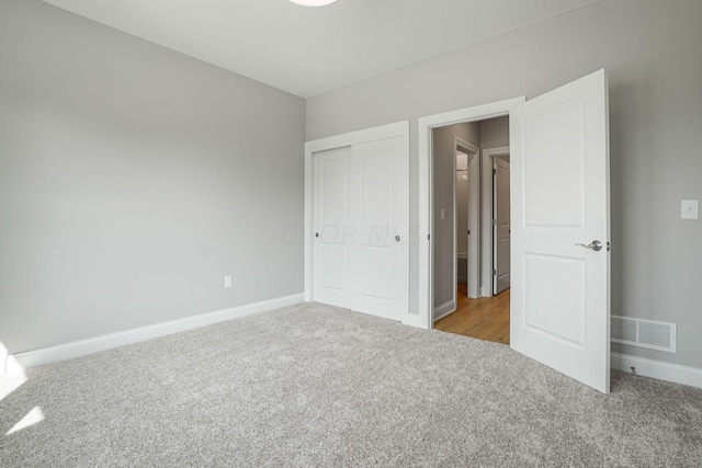 unfurnished bedroom with light carpet and a closet