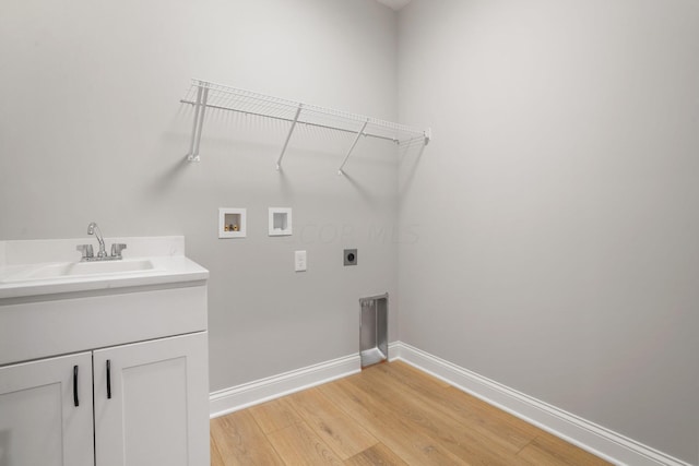 washroom featuring sink, cabinets, hookup for an electric dryer, hookup for a washing machine, and light hardwood / wood-style floors