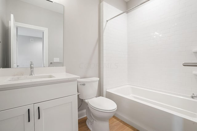 full bathroom featuring tiled shower / bath, toilet, vanity, and hardwood / wood-style flooring