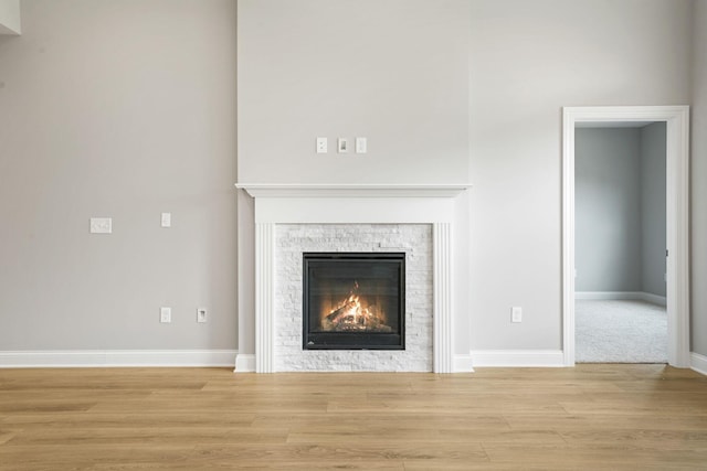 interior details featuring hardwood / wood-style floors and a stone fireplace