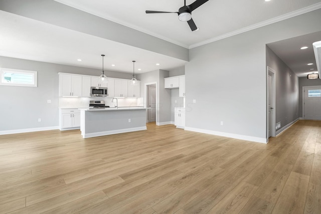 unfurnished living room with light hardwood / wood-style floors, a wealth of natural light, crown molding, and ceiling fan