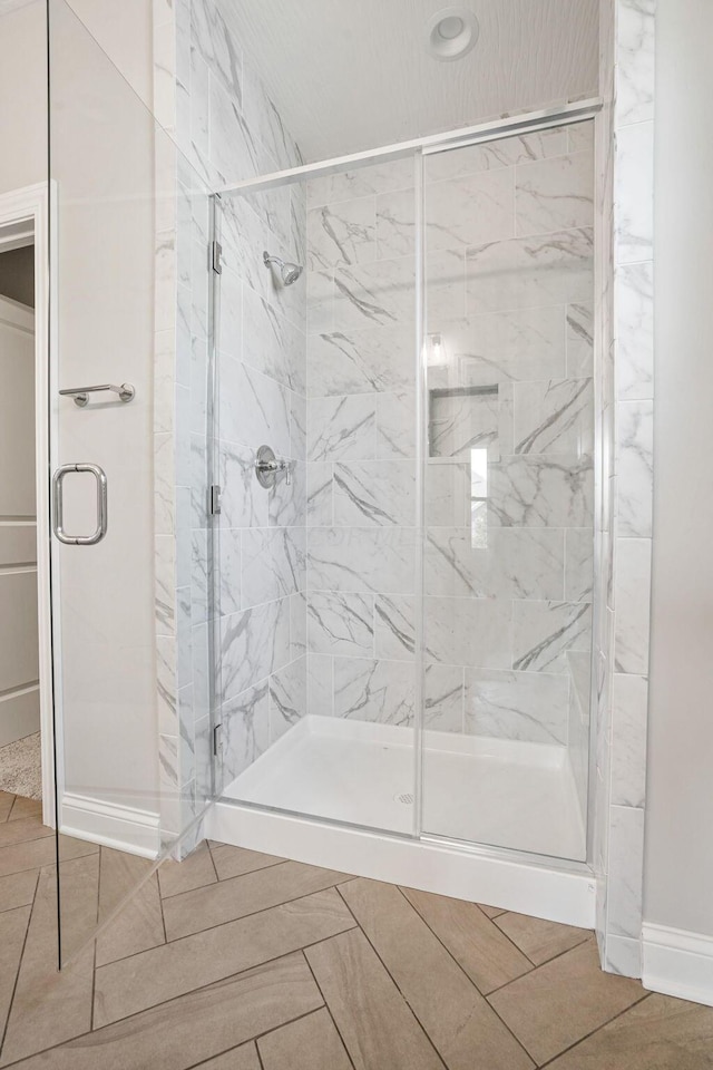 bathroom with tile patterned floors and a shower with door