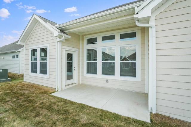 rear view of house with a yard, central AC, and a patio area