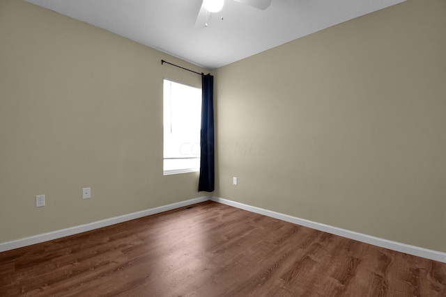 spare room with hardwood / wood-style flooring and ceiling fan