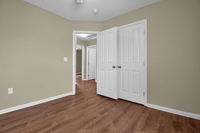 unfurnished bedroom with hardwood / wood-style floors and a closet