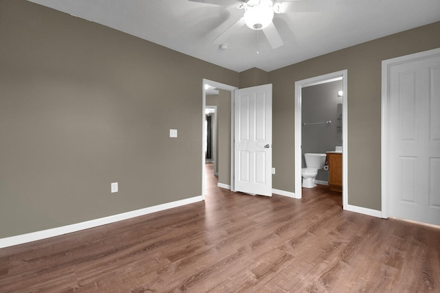 unfurnished bedroom featuring hardwood / wood-style flooring, ceiling fan, and connected bathroom