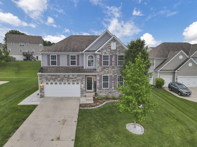 667 Green Forest Pl, Lithopolis, OH 43136 - view of front of home featuring concrete driveway, a front yard, stone siding, and an attached garage