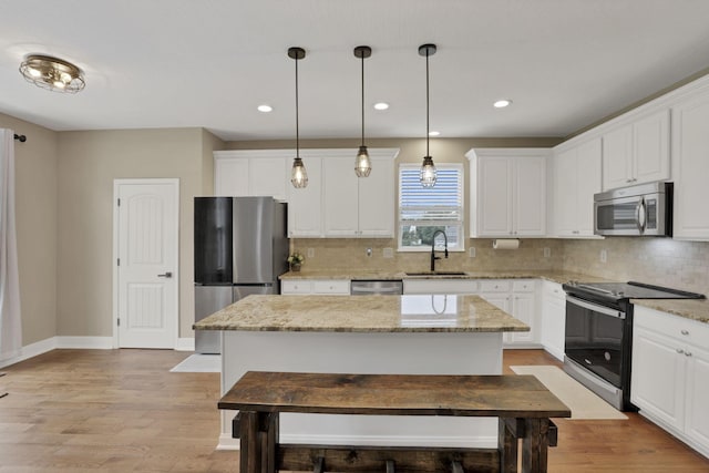 667 Green Forest Pl, Lithopolis, OH 43136 - kitchen featuring stainless steel appliances, a sink, a kitchen island, backsplash, and white cabinetry