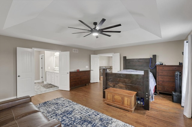 667 Green Forest Pl, Lithopolis, OH 43136 - bedroom with a tray ceiling, wood finished floors, ensuite bath, and ceiling fan