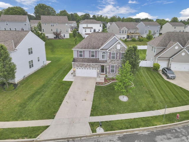 667 Green Forest Pl, Lithopolis, OH 43136 - view of front facade with a residential view, stone siding, concrete driveway, a garage, and a front yard