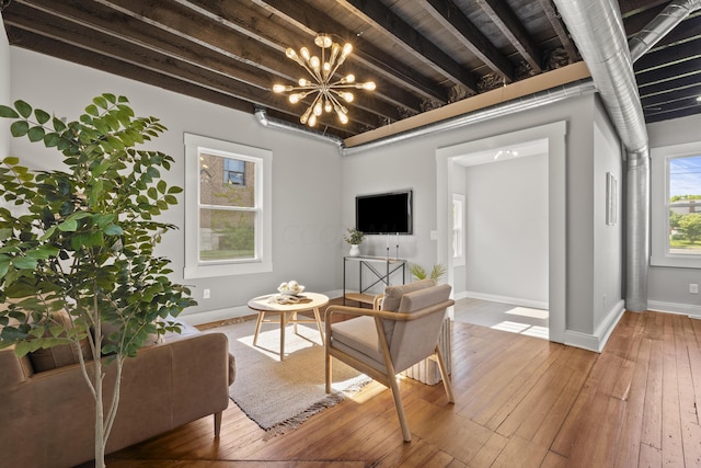 living room with hardwood / wood-style floors, a notable chandelier, and beam ceiling