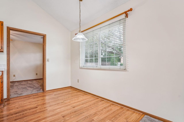 unfurnished room with hardwood / wood-style floors and vaulted ceiling