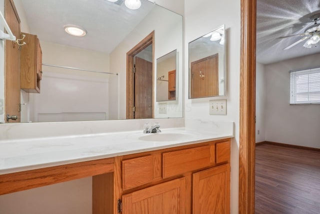 bathroom featuring ceiling fan, wood-type flooring, and vanity