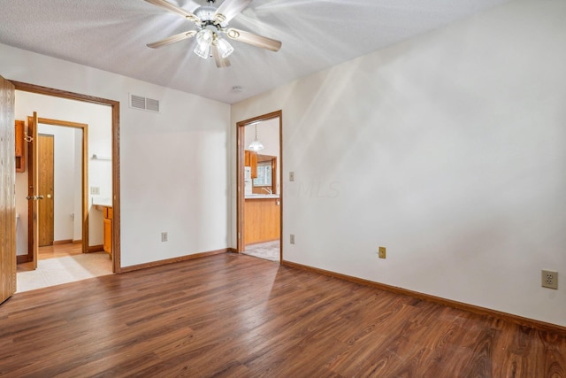 empty room featuring hardwood / wood-style flooring, ceiling fan, and a textured ceiling