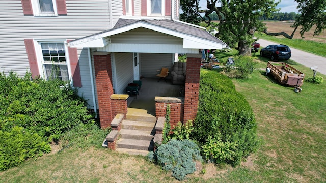 view of exterior entry with a lawn