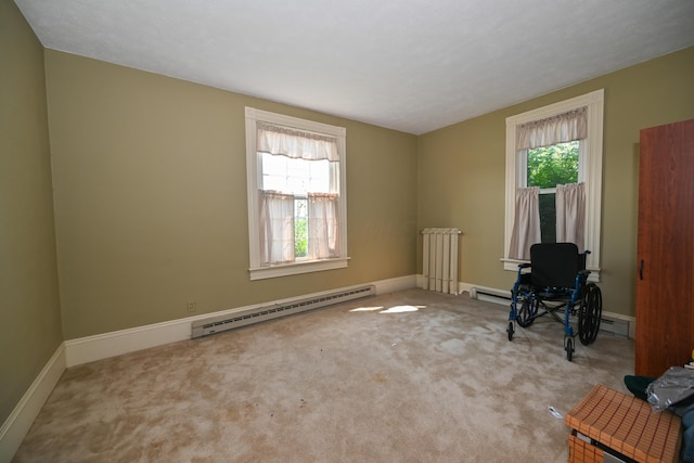 carpeted empty room featuring radiator, a wealth of natural light, and a baseboard radiator