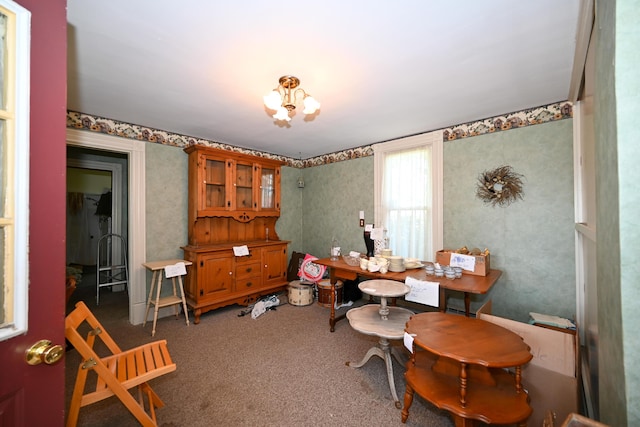 misc room featuring a chandelier and dark carpet