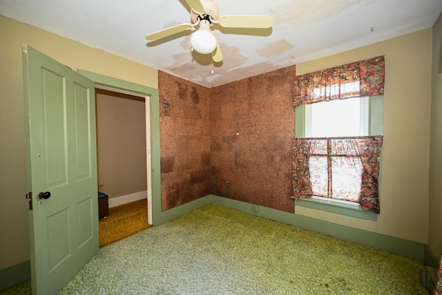 carpeted empty room featuring ceiling fan