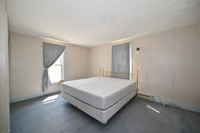 carpeted bedroom featuring a textured ceiling and a baseboard heating unit